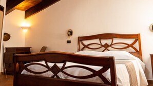 A bedroom with a wooden bed, a skylight, and a wall-mounted light fixture. - Villetta Capodimonte Guest House (Naples)