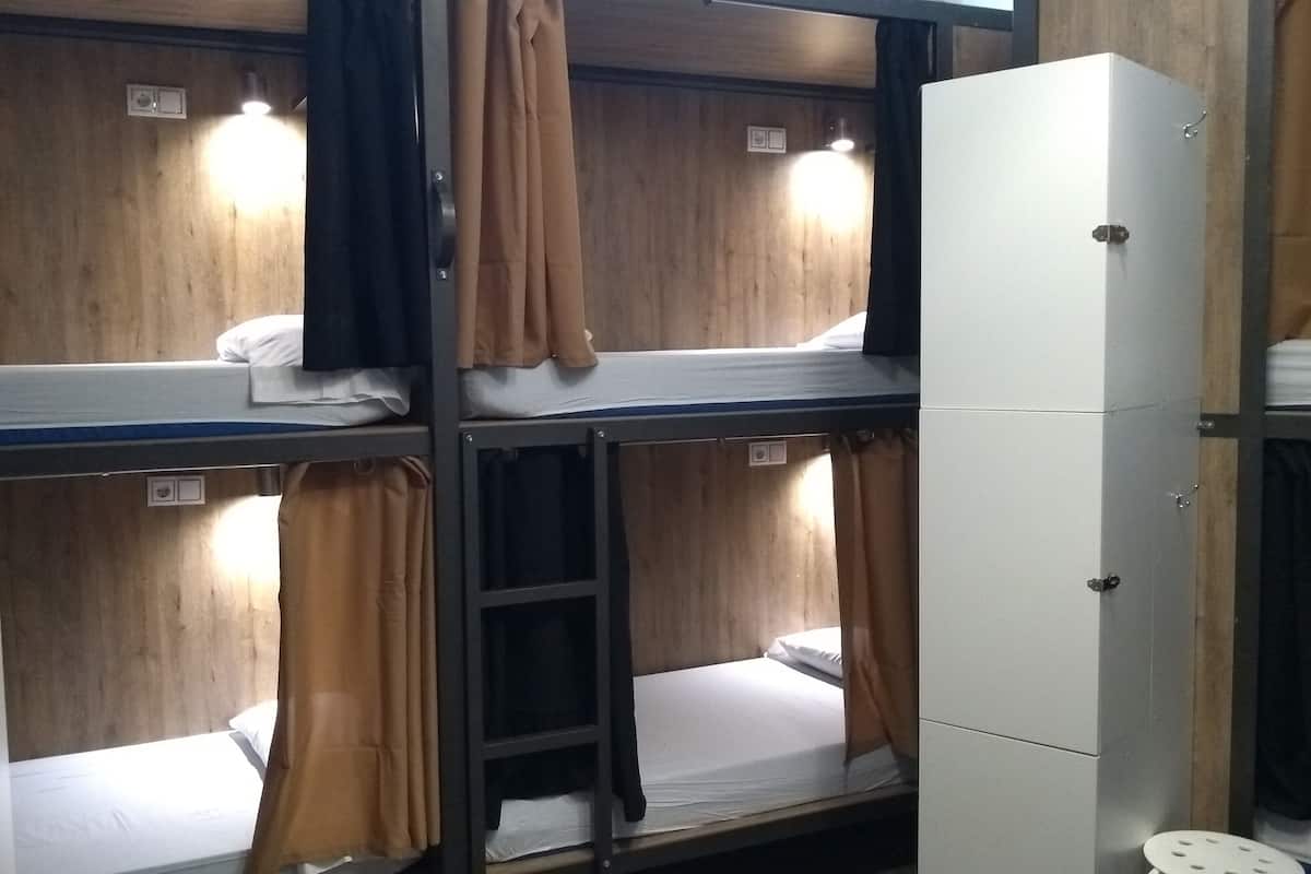 Ein Schlafzimmer mit Etagenbetten, Holzwänden und einem weißen Schrank.