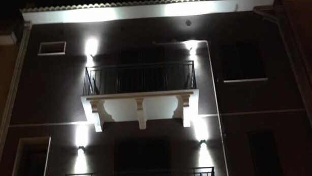 A multi-story building with a balcony, a garage door, and multiple windows. - The Liberty Palace b&b (Campobello di Licata)