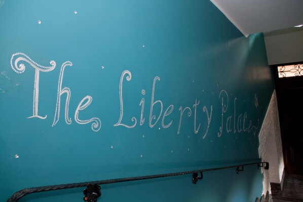 Experience the grandeur of The Liberty Palace, featuring a beautifully designed wall with a decorative script and elegant details.