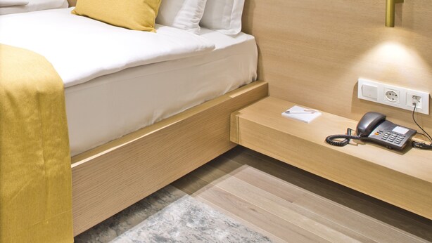 A modern hotel room with a wooden bed, a bedside phone, and a large abstract painting on the wall. - Hotel 86 by Katipoglu (Izmir)