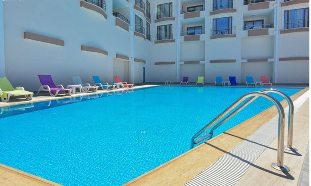 A swimming pool with multiple levels of balconies, each with a railing and a few windows.