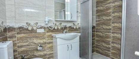 Un baño con inodoro, lavamanos y ducha.
