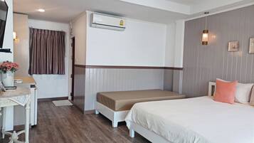 Camera d'albergo con un letto, una scrivania, una sedia, un condizionatore d'aria e un lampadario a parete.