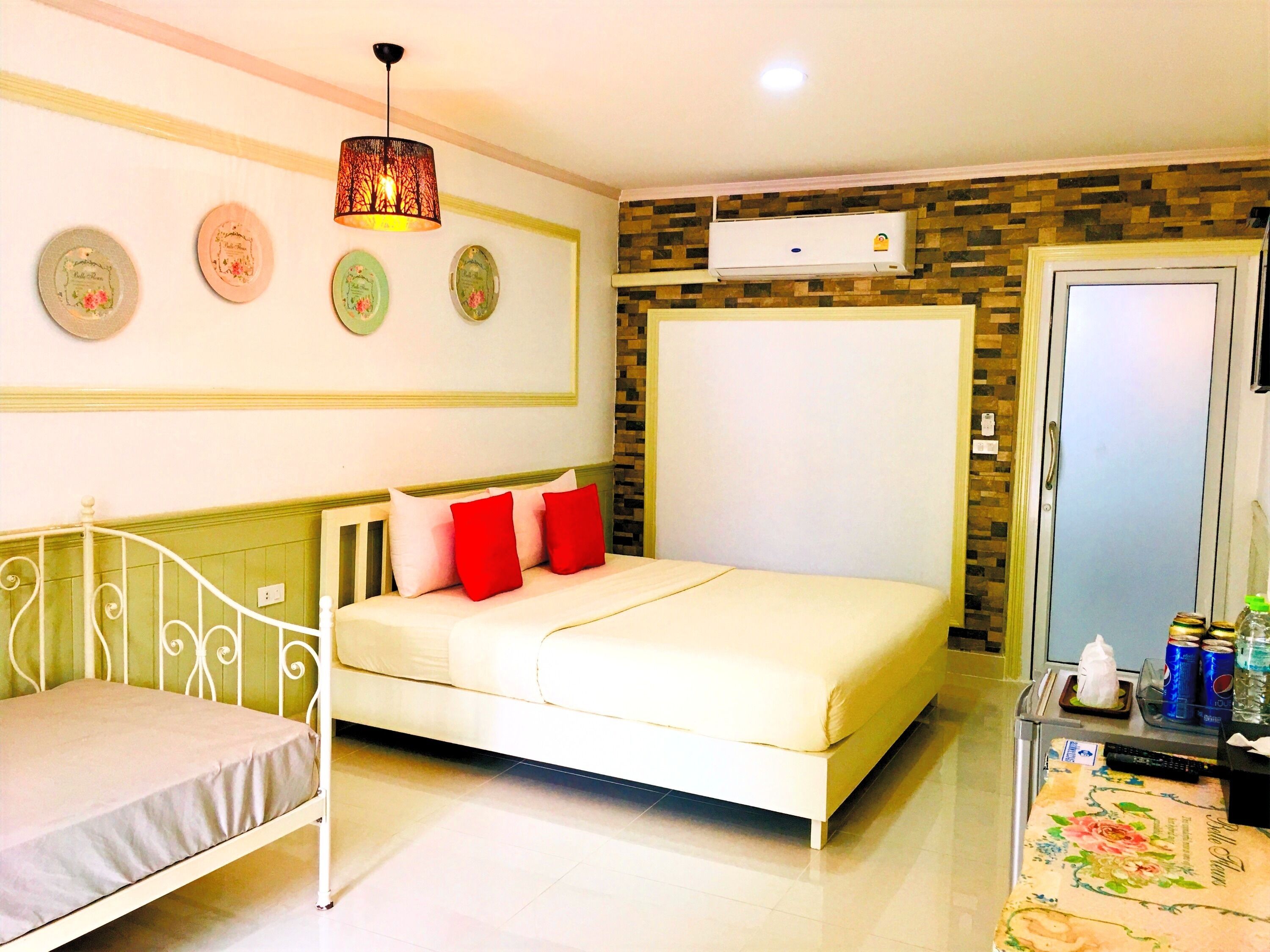 Un dormitorio con cama, mesita de noche, aire acondicionado y placas decorativas en la pared.