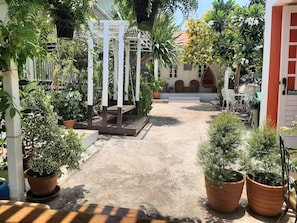 A courtyard with a pergola, potted plants, and outdoor seating.