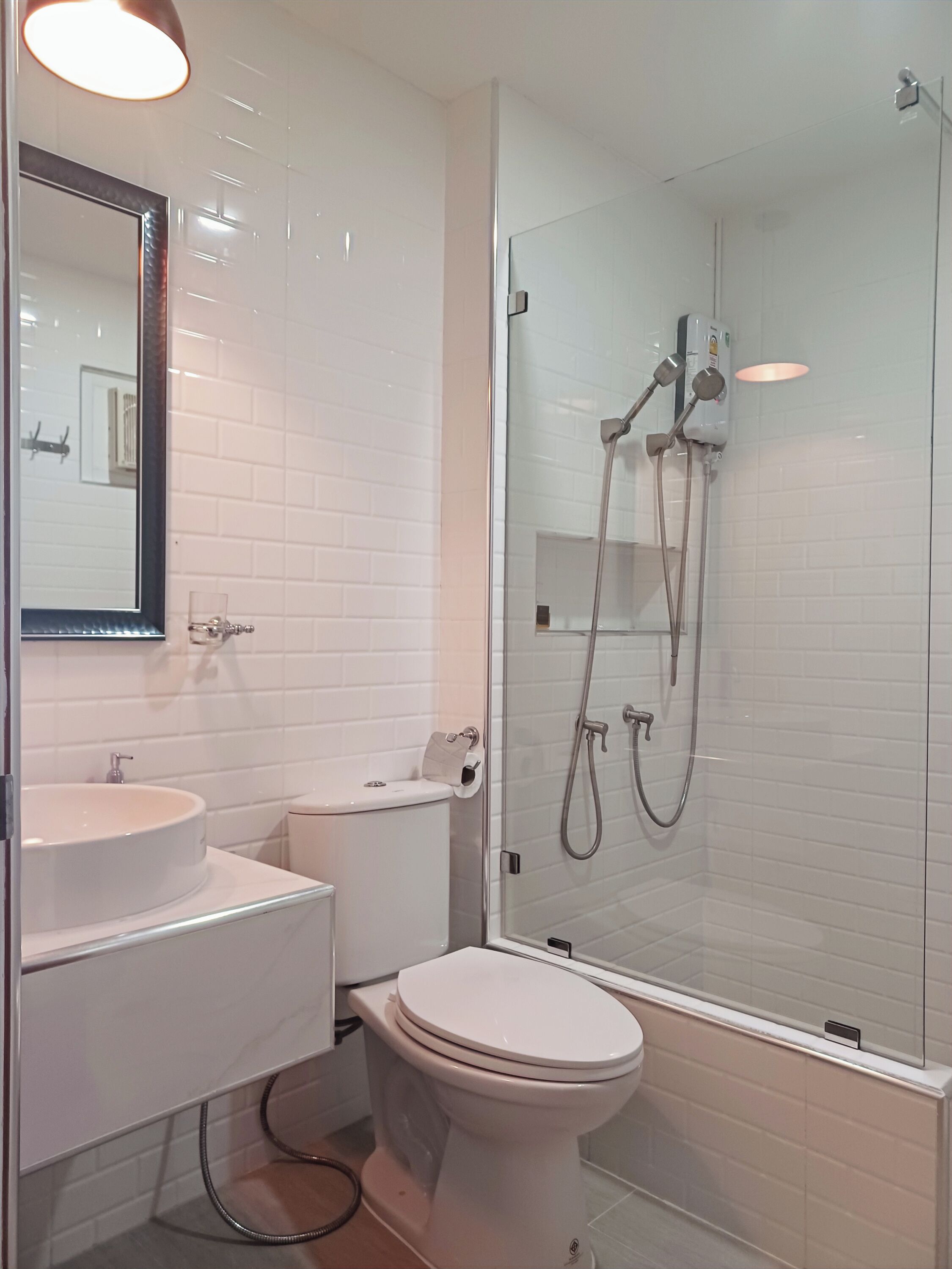 A modern bathroom with a glass-enclosed shower, a round sink, and a toilet.