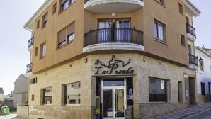 Um edifício com vários andares, com espaço comercial no térreo, varandas e entrada visível.