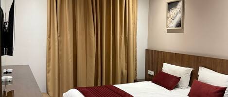 Una habitación de hotel moderna con una cama grande, un escritorio y un cuadro en la pared.