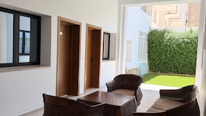 Un interior moderno con comedor, ventanas amplias y vistas a un jardín verde.