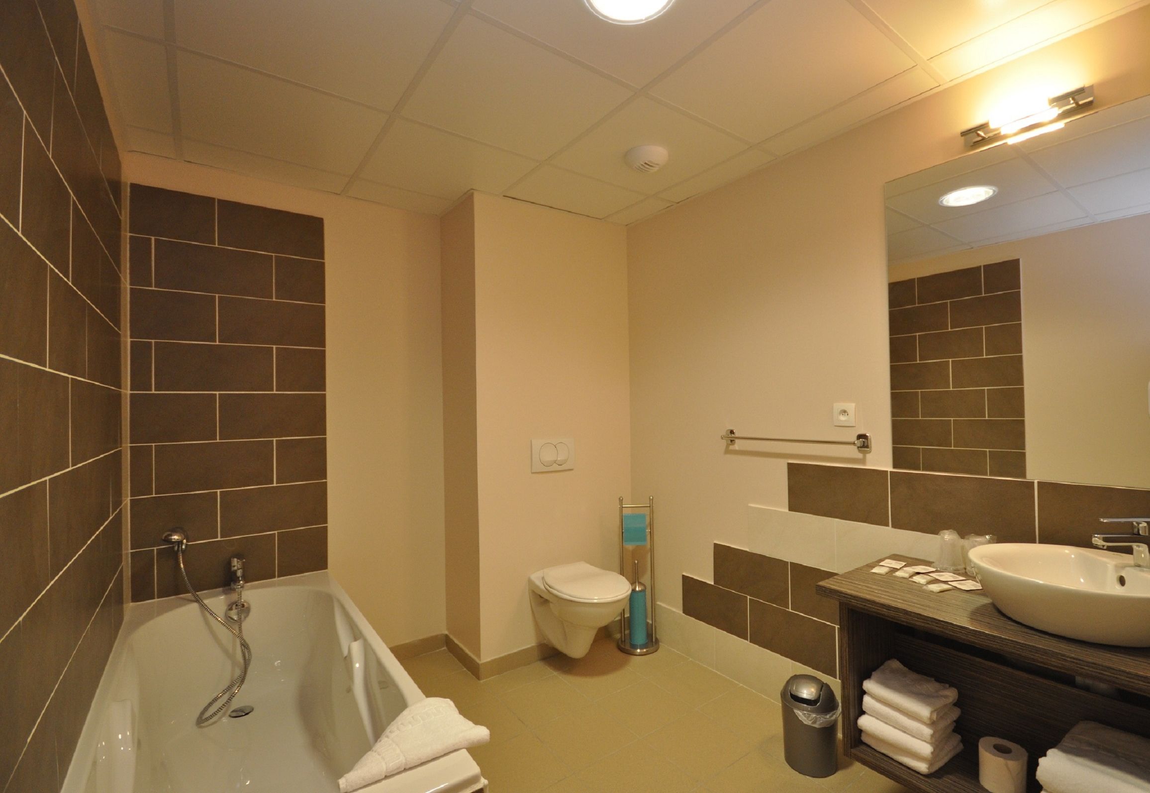 A modern bathroom with a bathtub, toilet, and sink.