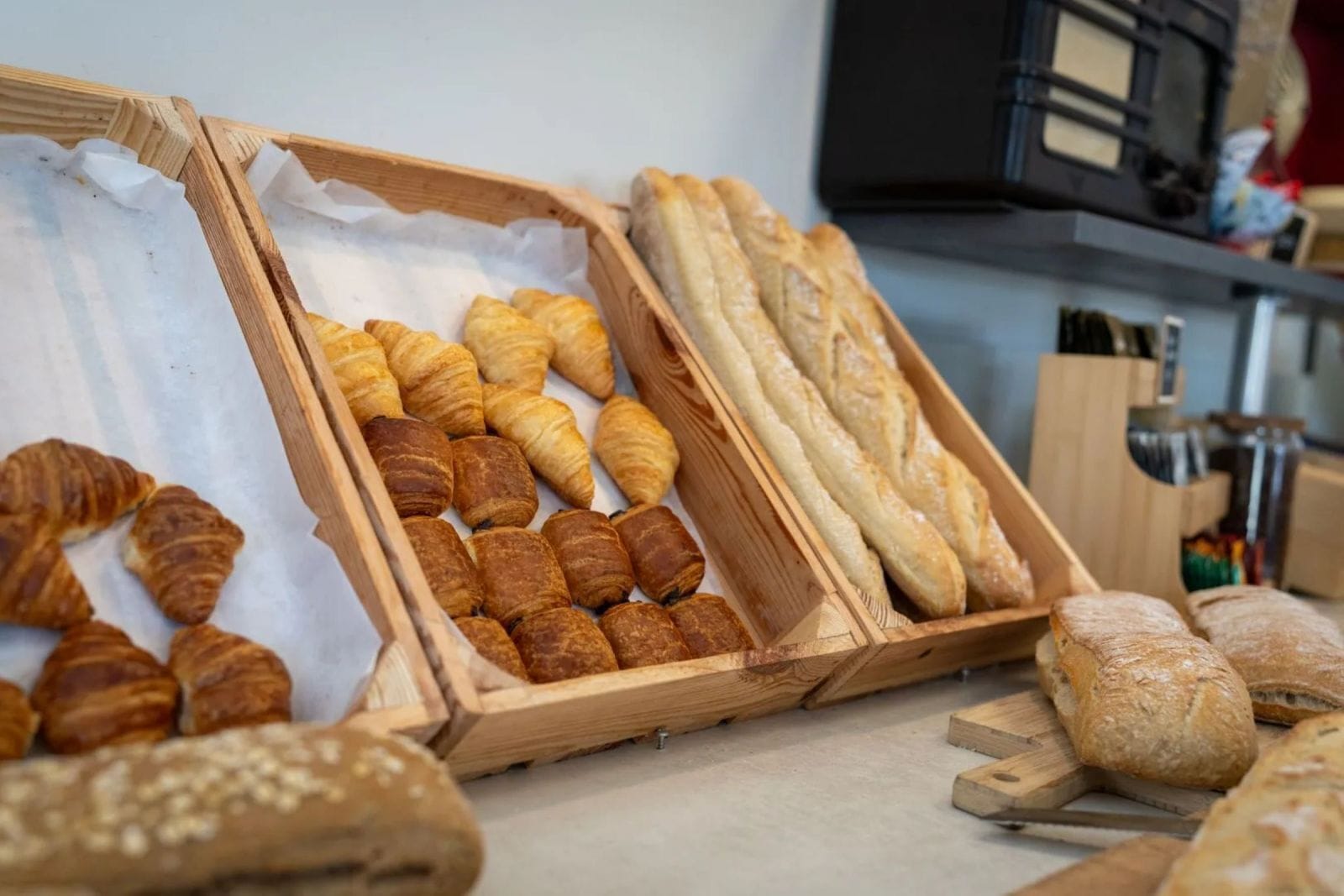 Une variété de produits de boulangerie présentés dans des plateaux en bois.