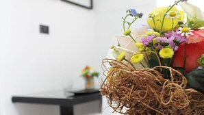 Un coin repas avec une table et des chaises, un vase rempli de fleurs et des tableaux encadrés accrochés au mur.