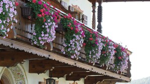 Un edificio de madera tradicional con un balcón decorado con macetas colgantes de flores.