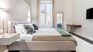 Une chambre moderne avec un grand lit, un bureau et un téléviseur.