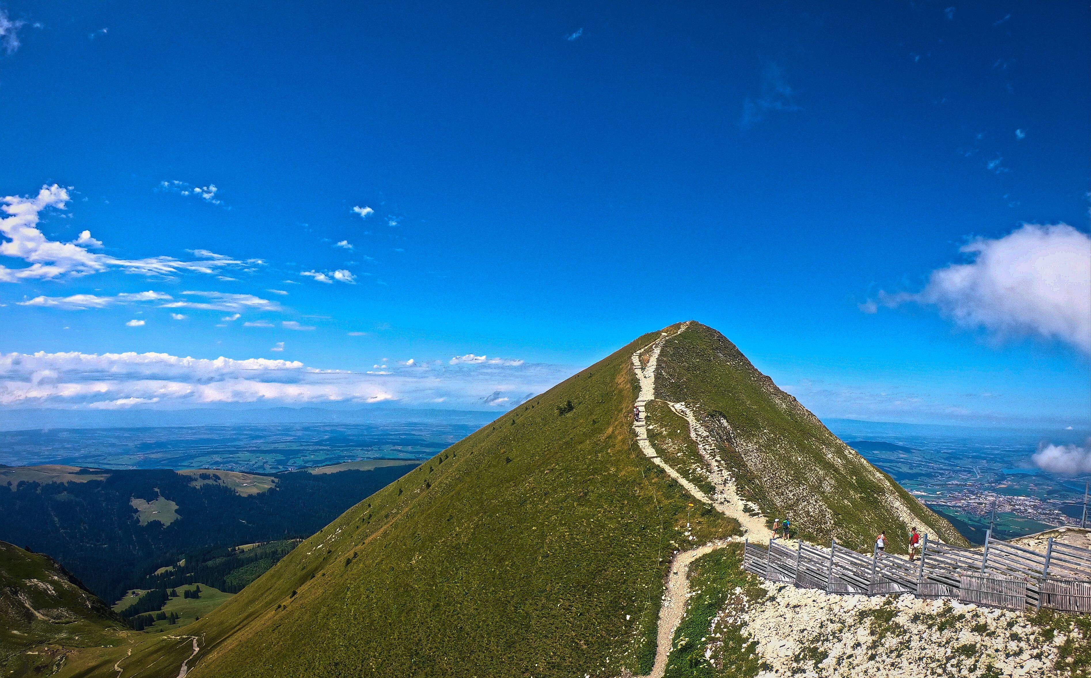 A mountain with a clear sky and a trail leading to the summit.