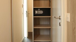 A walk-in closet with multiple shelves and a built-in safe. - Wego Hotel (Vuadens)