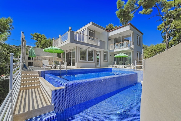 Utomhuspool, parasoller och solstolar