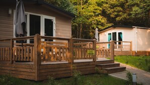 A small cabin with a wooden deck and a covered porch. - Eurocamp Spreewaldtor (Märkische Heide)