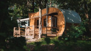 A wooden cabin with a curved roof, a deck, and a small porch. - Eurocamp Spreewaldtor (Märkische Heide)