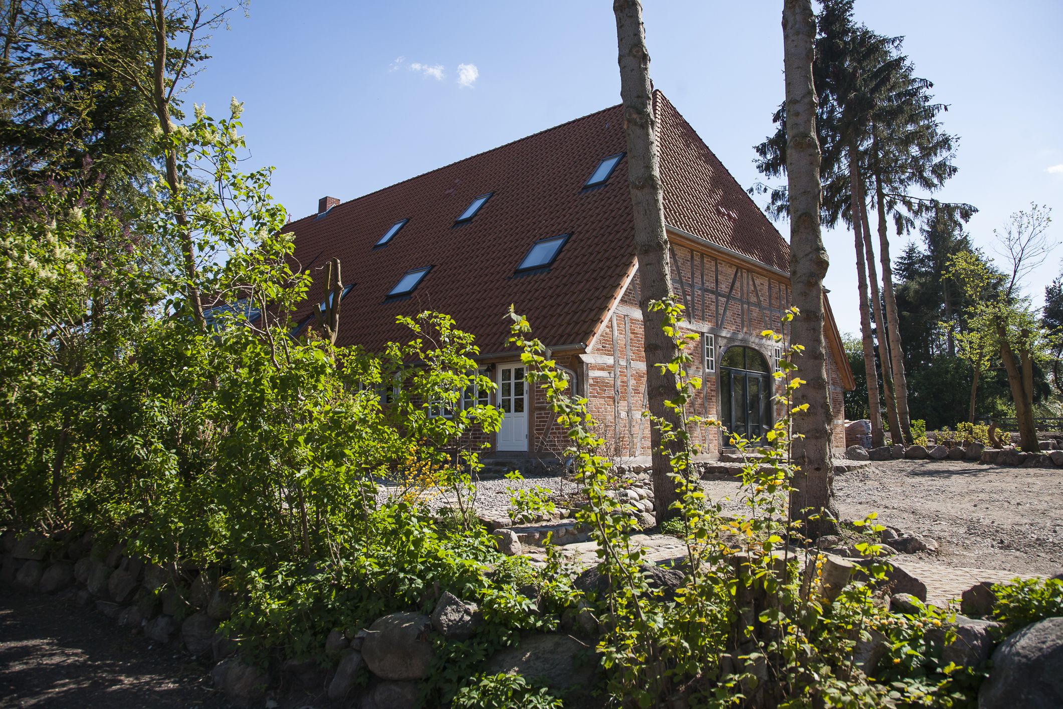 A traditional building with a sloped roof, stone walls, and a small porch area.