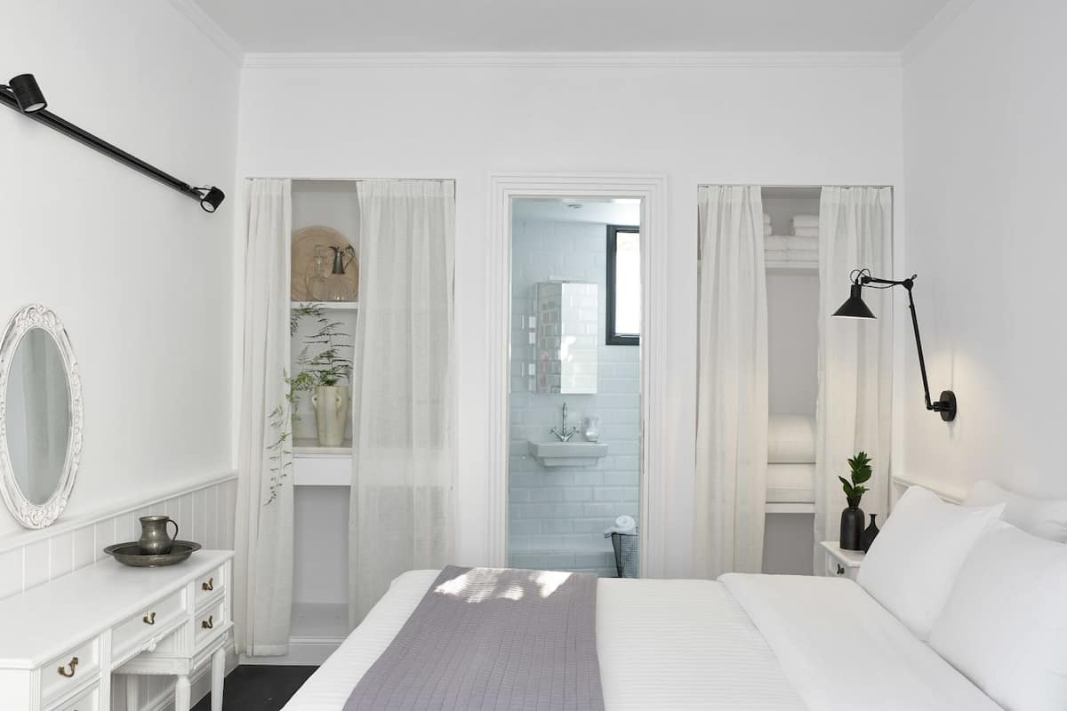 A bedroom with a bed, a dresser, a mirror, and a nightstand.