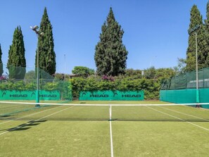 En tennisbane med net og grønne bannere med ordet "HEAD".