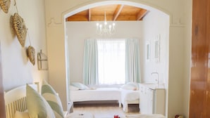 Ein Schlafzimmer mit einem großen Bett, einem Schreibtisch und einer Chandelüster.