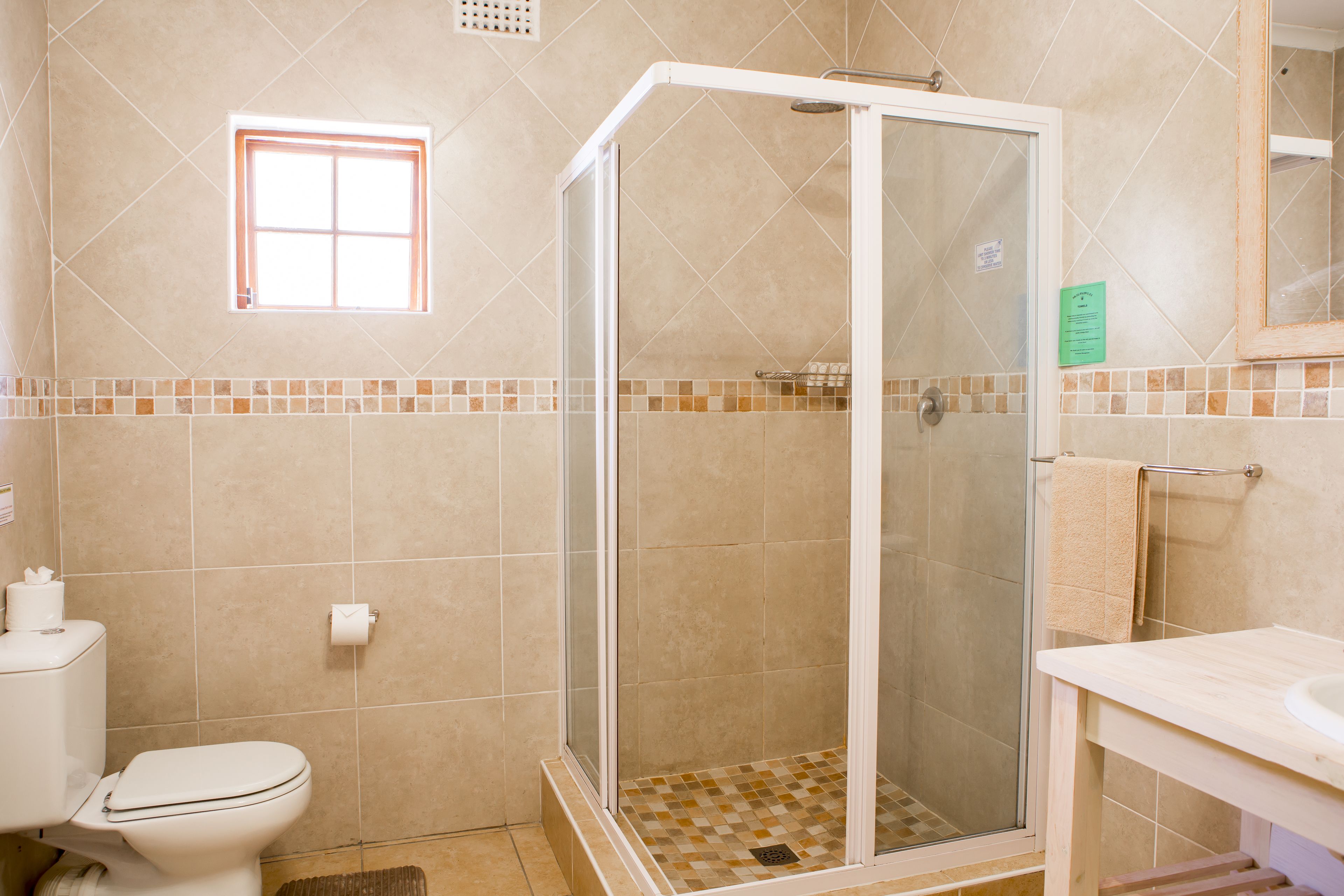 A bathroom with a shower, toilet, and sink.
