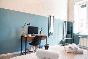 A bedroom with a desk, chair, computer, and a bed with rolled towels. - B&B  Lumiere Roma (Rome)