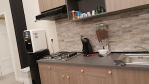 A modern kitchen with a built-in gas stove, a coffee machine, and a water dispenser. - B&B  Lumiere Roma (Rome)