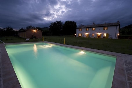 Una piscina al aire libre de temporada, sombrillas