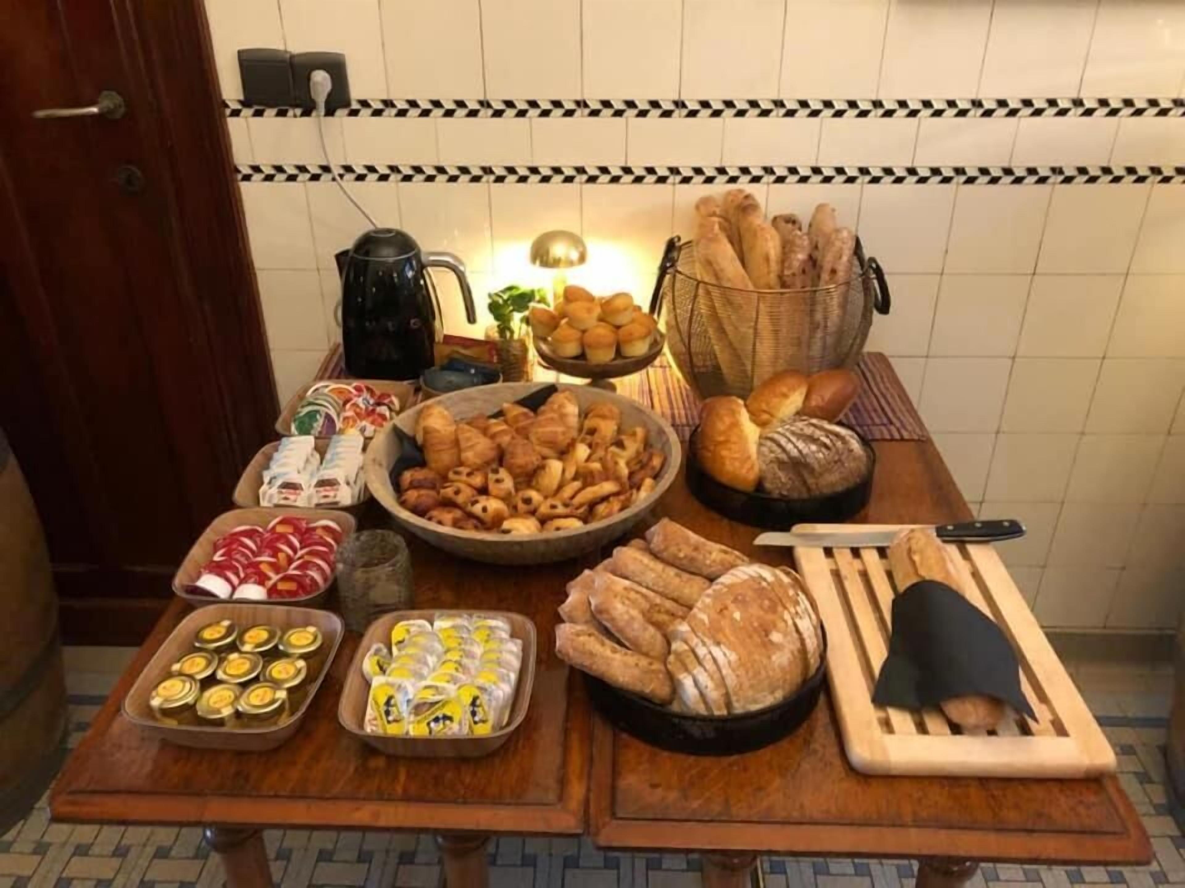 Una encimera de cocina con diversas preparaciones horneadas, como pan, pasteles y galletas.