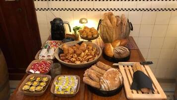 Una encimera de cocina con diversas preparaciones horneadas, como pan, pasteles y galletas.