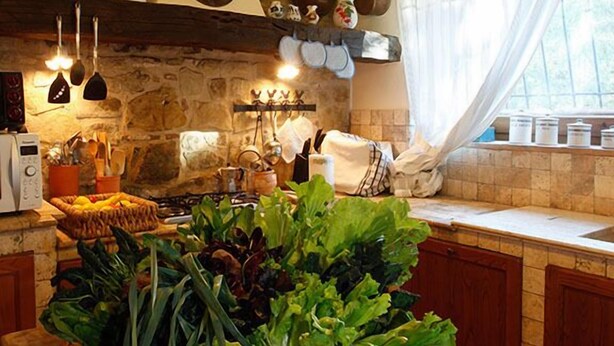 A kitchen with a wooden countertop, a hanging light fixture, and a stone wall. - Verdidea - Villa la Felce (Cetona)