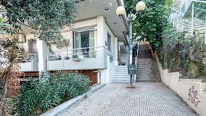 Un immeuble résidentiel avec un chemin dallé menant à un escalier.