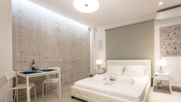 Une chambre à coucher moderne avec un grand lit, une petite table et des chaises.