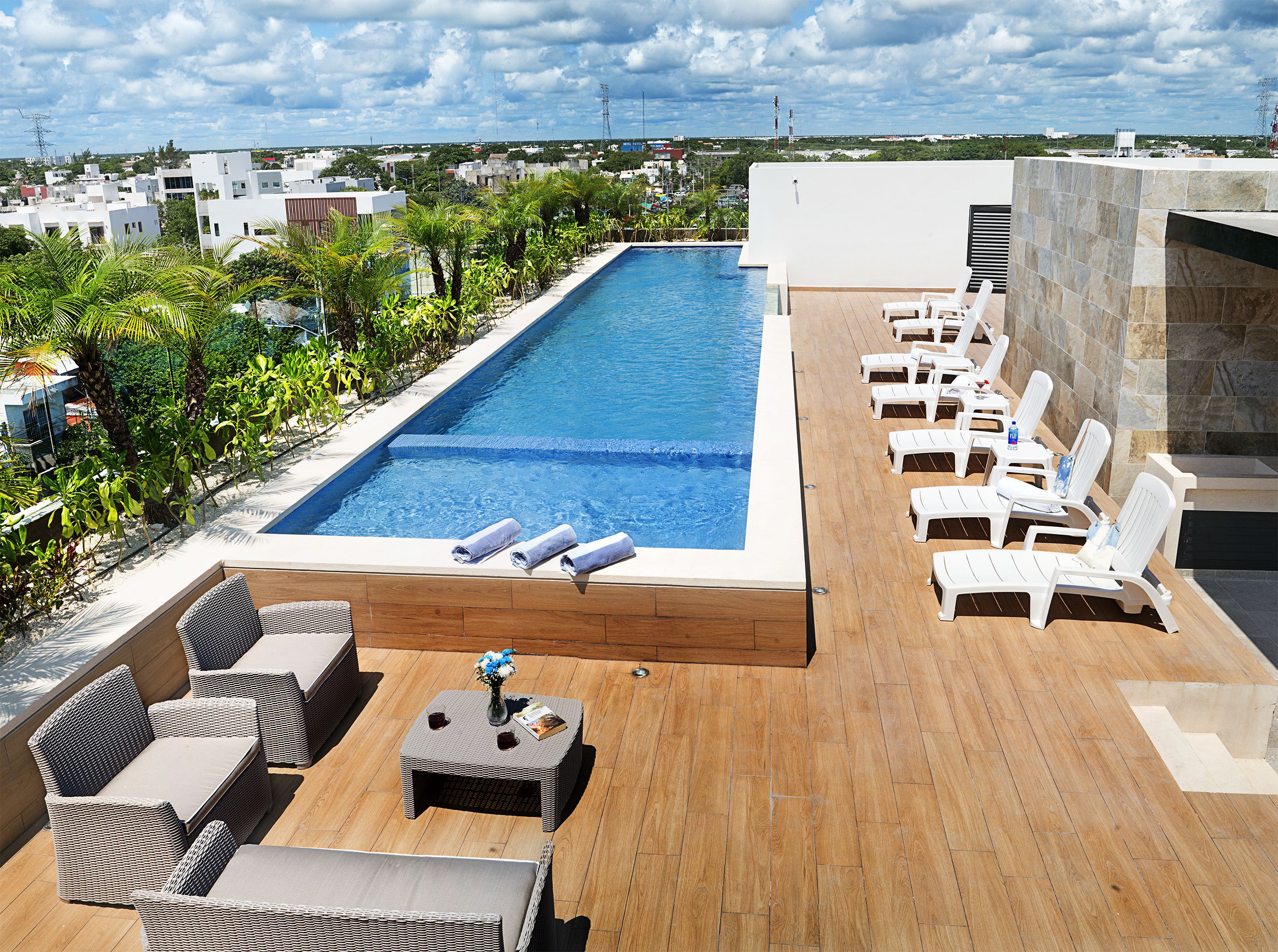 Ein Pool auf dem Dach mit Liegestühlen und einer Holzterrasse.