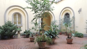 A courtyard with potted plants and a tiled floor.
