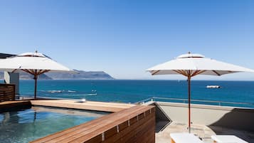 Een buitenzwembad, parasols voor strand/zwembad