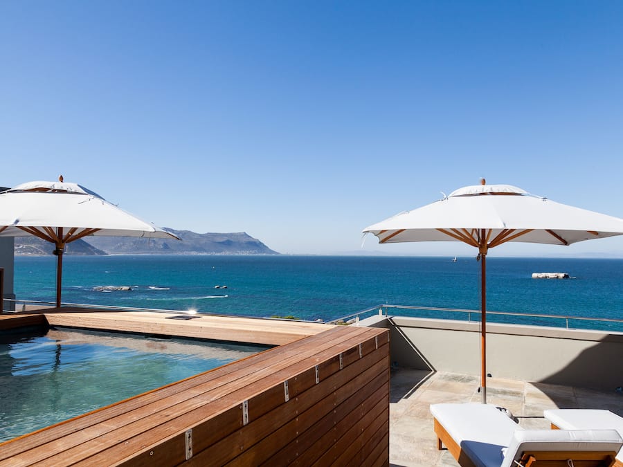 Een buitenzwembad, parasols voor strand/zwembad