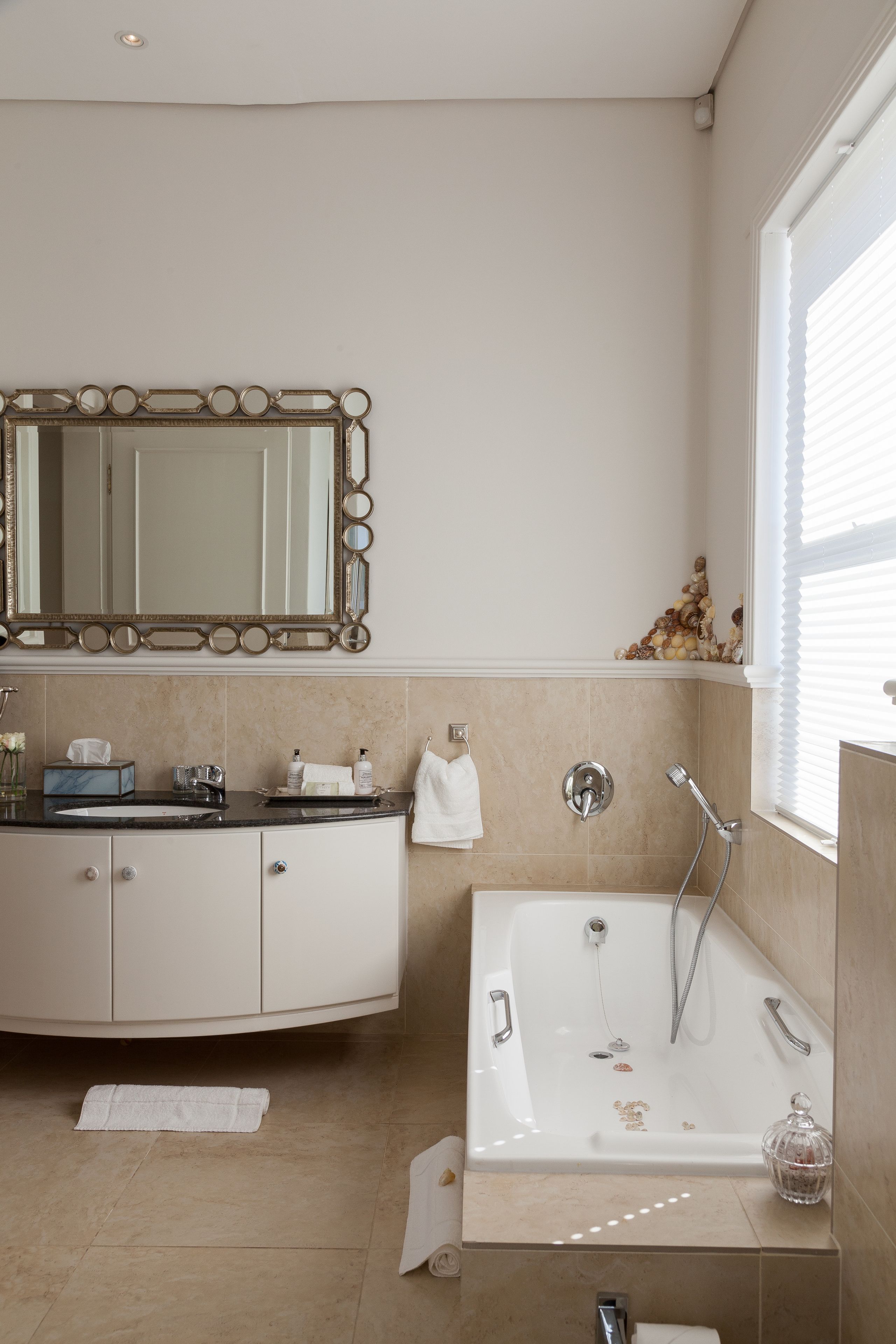 Un bagno con un mobile lavabo, lavandino, specchio e vasca.