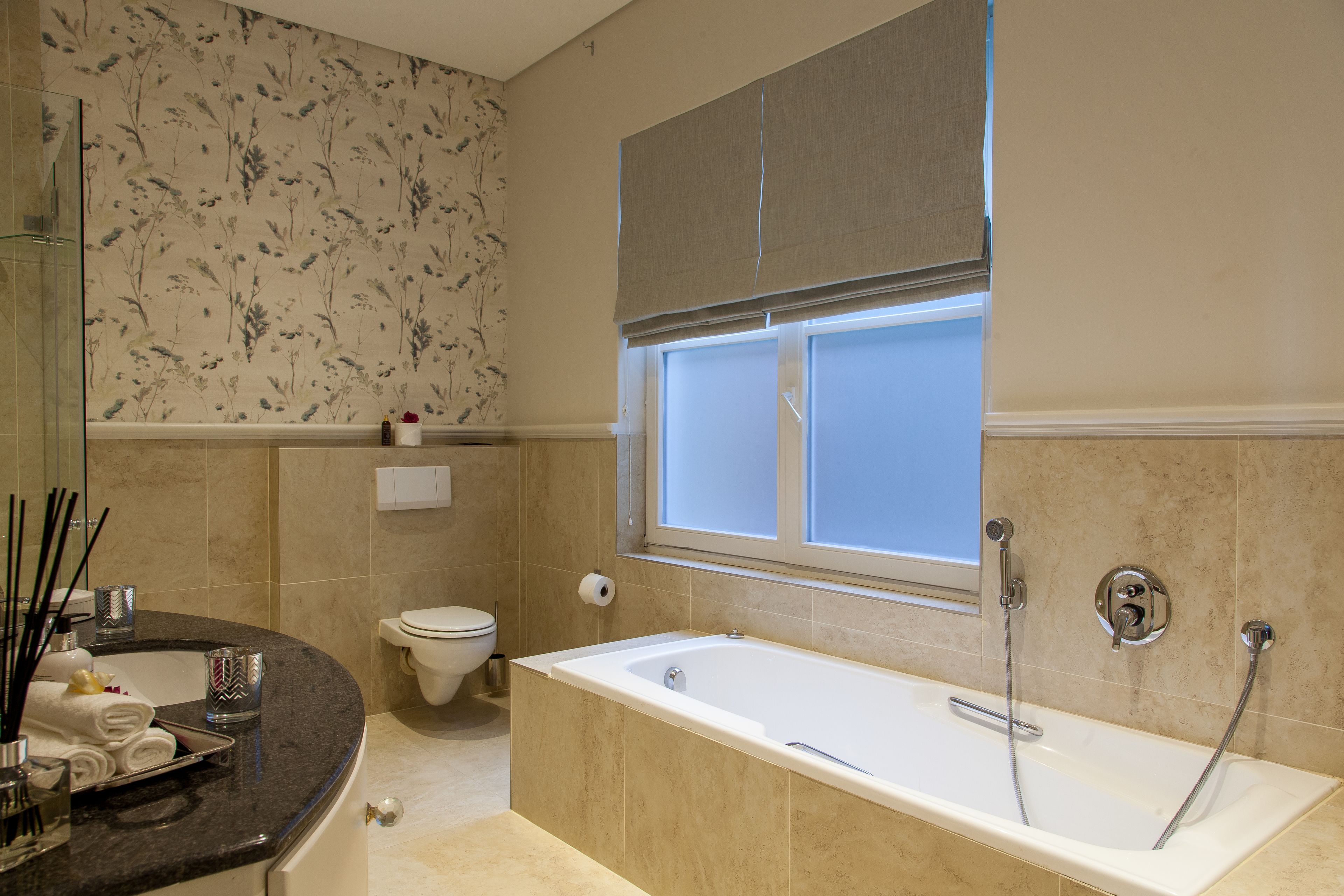 Ein Badezimmer mit Badewanne, Toilette, Fenster und Dusche.