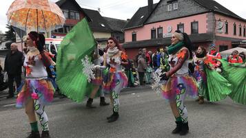 A street parade with participants in colorful costumes.