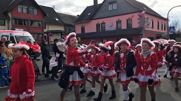 Een groep mensen in feestelijke kleding loopt over een straat.