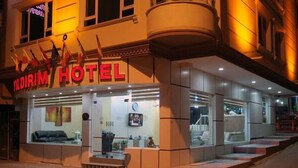Exterior del hotel Yildirim, con fachada moderna, ventanas amplias y una entrada destacada.