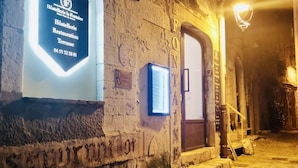 A stone building with a sign for a restaurant and terrace. - Hostellerie la Fontaine (Saint-Paul-de-Vence)