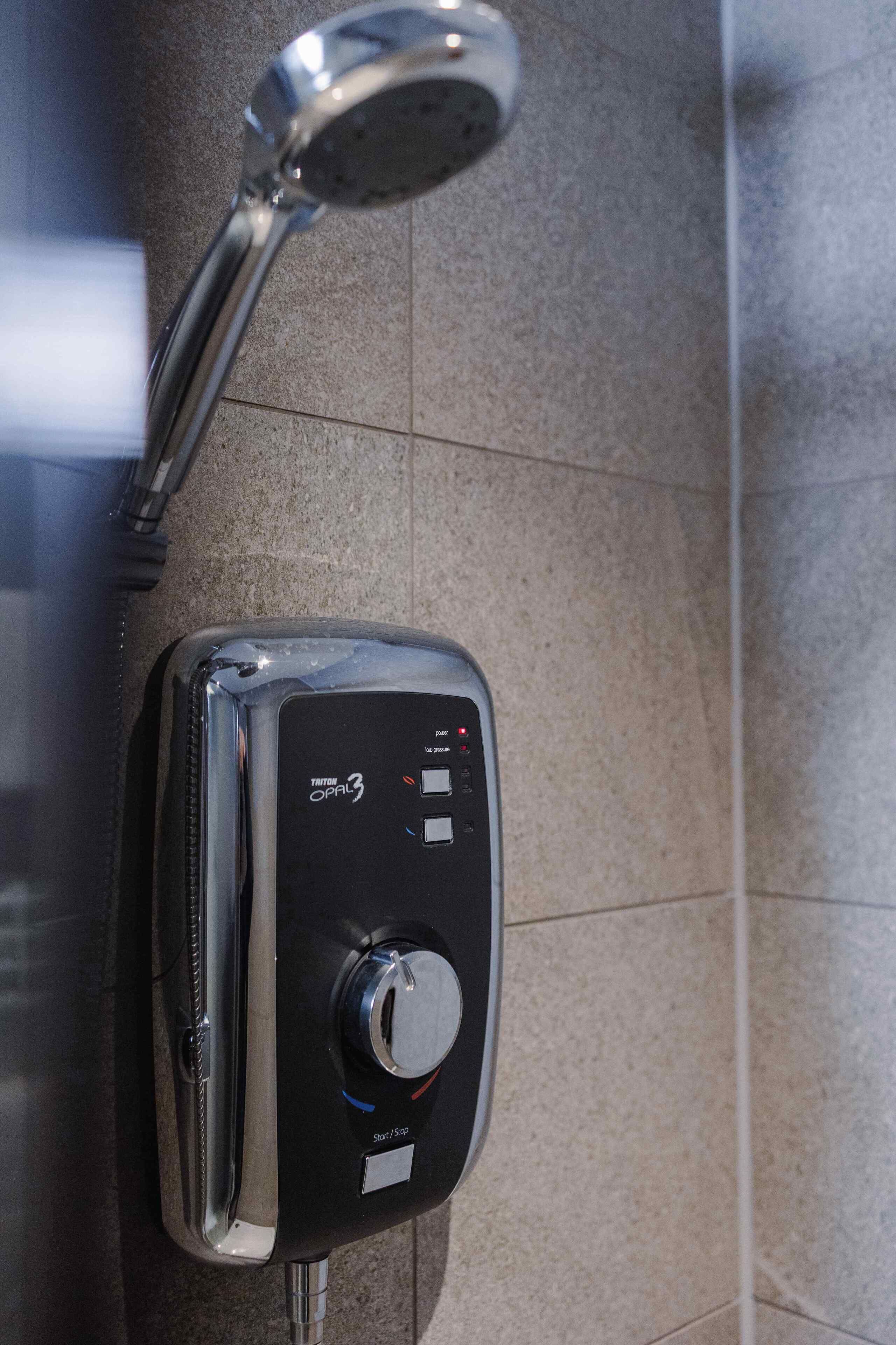 A wall-mounted control panel with a digital display and a rotary knob, likely for a shower or spa system.