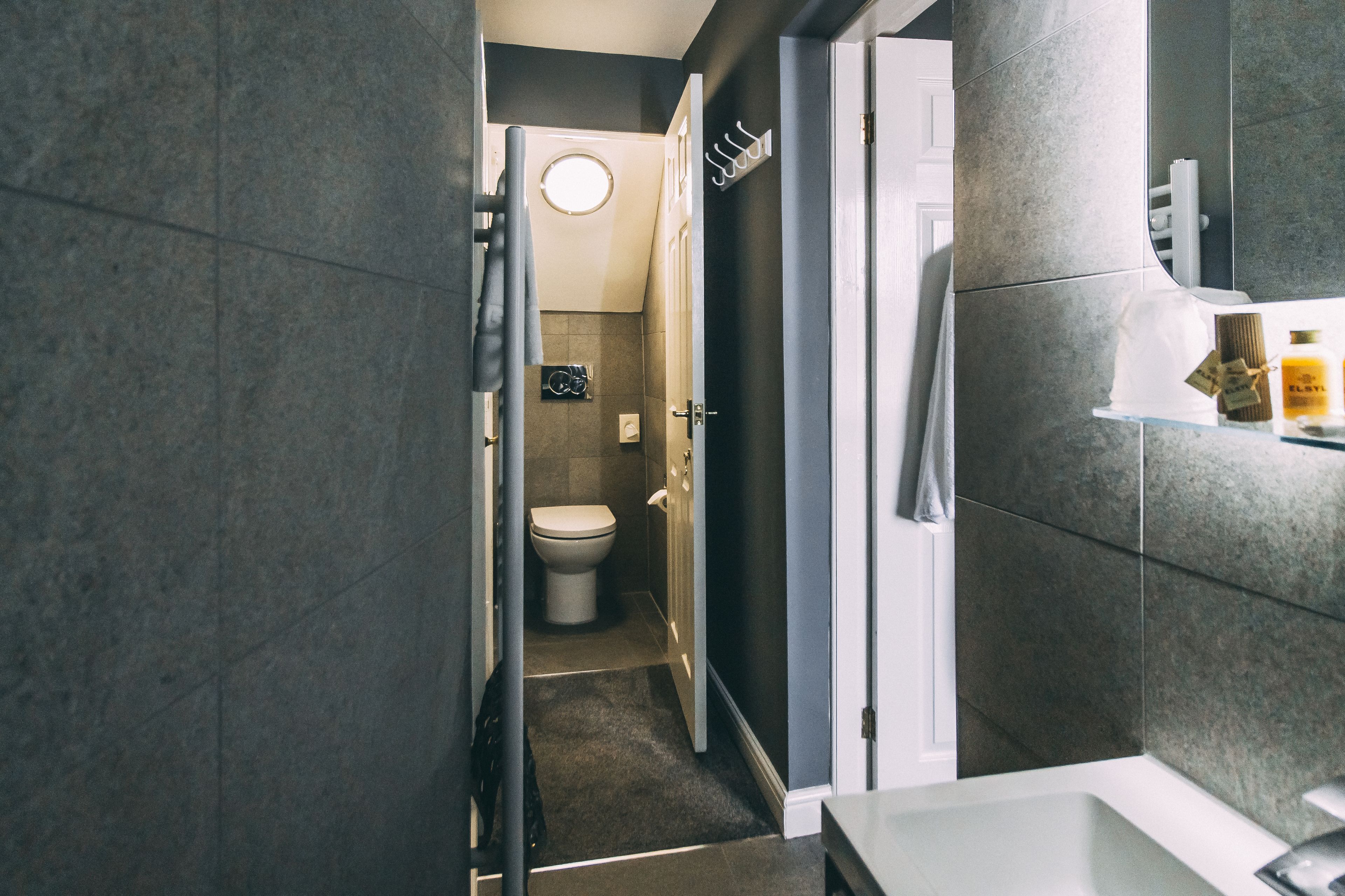 A modern bathroom with a toilet, a shower, and a sink.