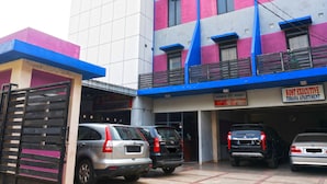 A multi-story building with a sign for 'KOST EXECUTIVE TOBANA APARTMENT'.
